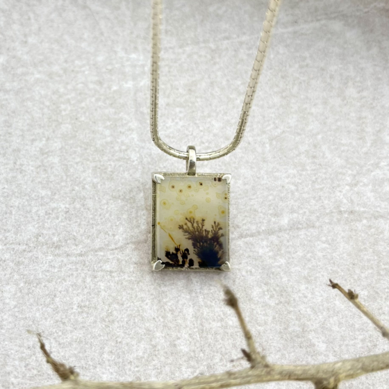 Close-up of Forestfall Light pendant showing intricate golden dots and dark dendrites in a rectangular gemstone, handcrafted in silver.