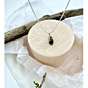 Full-view shot of Whispered Silhouettes pendant hanging against a soft beige background, emphasizing its nature-etched Shazar stone and minimalist setting.