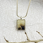 Close-up of Forestfall Light pendant showing intricate golden dots and dark dendrites in a rectangular gemstone, handcrafted in silver.